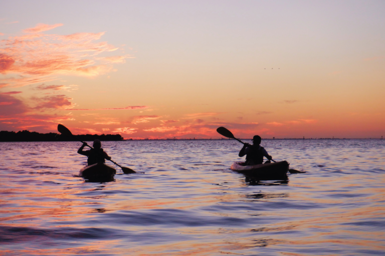 two kayakers at sunset with horizon behind them